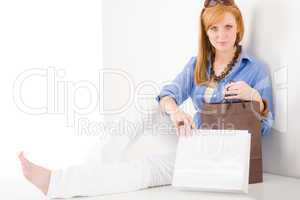 Shopping young woman with paper bag sitting