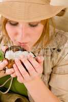 Safari young woman drink from coconut