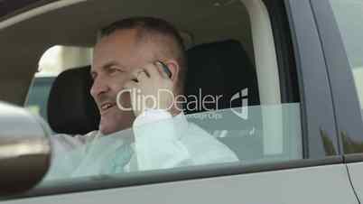 Businessman in car talking on mobile phone