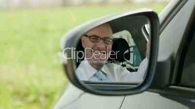 Businessman in car smiling at camera