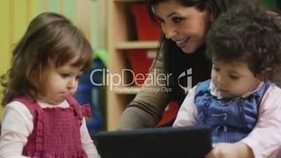 Teacher using tablet pc with children at school