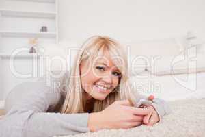 Beautiful blond woman writing a text on cell phone and posing ly