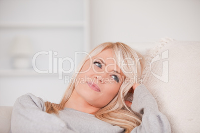 Junge blonde Frau entspannt auf der Couch