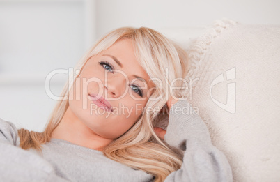 Junge blonde Frau liegt auf dem Sofa und entspannt