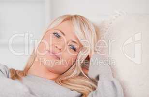 Junge blonde Frau liegt auf dem Sofa und entspannt