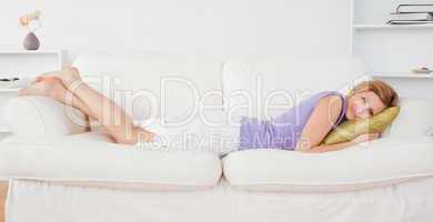 Attractive woman posing and smiling while lying on a sofa
