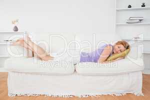 Attractive woman taking a rest lying on a sofa