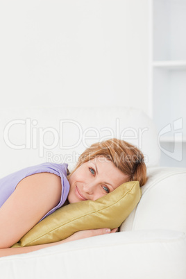 Portrait of a good looking woman posing and smiling while lying