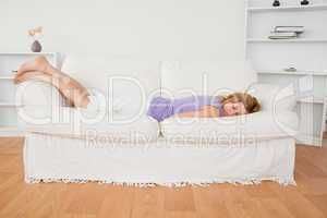 Attractive woman sleeping while lying on a sofa