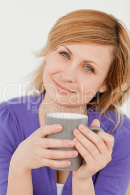 Portrait of a beautiful red-haired woman holding a cup of coffee