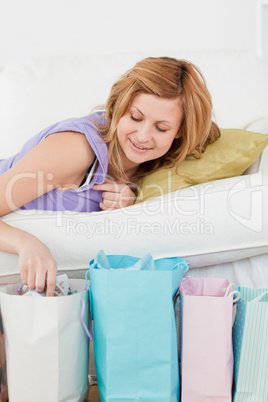 Attractive woman lying on the couch with her shopping bags