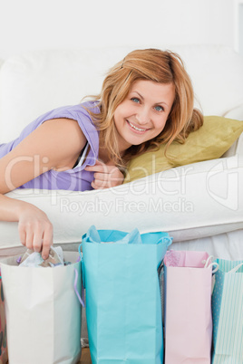 Pretty woman lying on the couch with her shopping bags