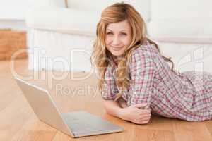 Young woman looking at the camera while chatting on her laptop