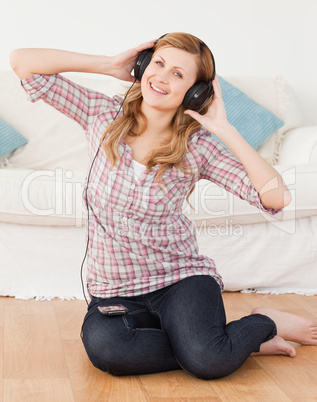 Blond-haired woman listening to music while sitting on the floor