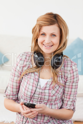 Happy blond-haired woman with headphones and mp3 player