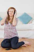 Attractive blond-haired woman listening to music with headphones