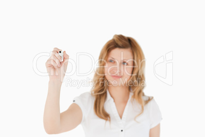 Blonde woman drawing a scheme looking towards the camera
