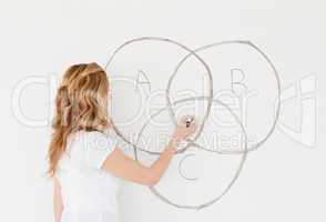 Blond-haired teacher drawing a scheme on a white board