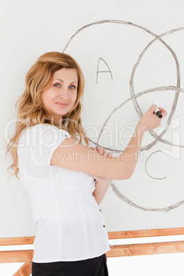 Teacher looking at the camera while drawing a scheme