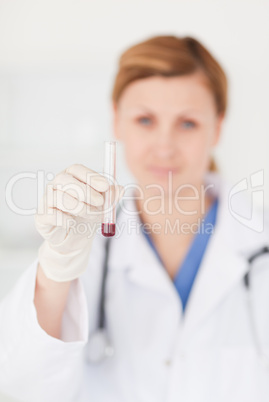 Female scientist looking at the camera while holding a test tube