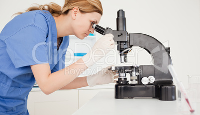 Female scientist looking through a microscope