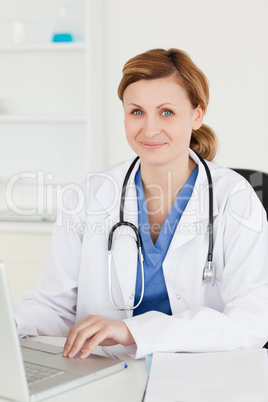 Smiling doctor working on her laptop