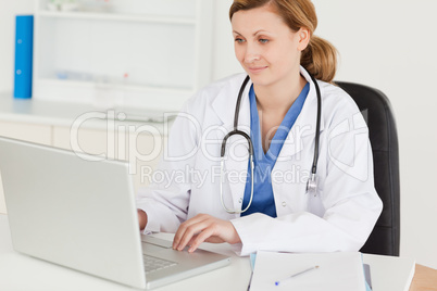 Attractive female doctor working on her laptop