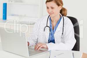 Attractive female doctor working on her laptop
