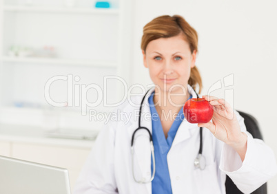 Young female doctor showing a red apple