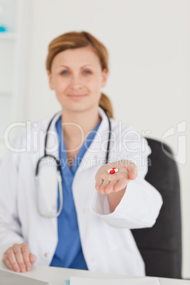 Blond-haired doctor showing pills to the camera