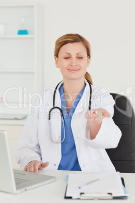 Attractive female doctor showing pills to the camera