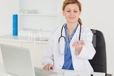Pretty female doctor showing pills to the camera