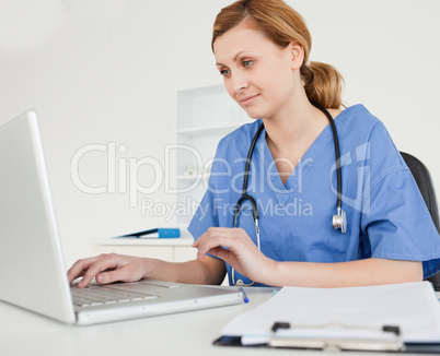 Cute female doctor working on her laptop
