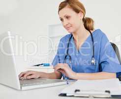 Cute female doctor working on her laptop