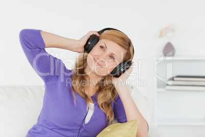 Attractive red-haired woman listening to music and enjoying the