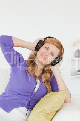 Good looking red-haired woman listening to music and enjoying th