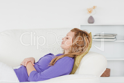 Pretty woman taking a rest lying on a sofa