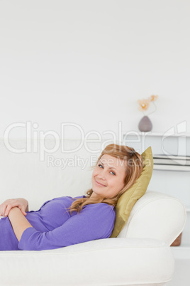 Beautiful woman taking a rest and posing while lying on a sofa