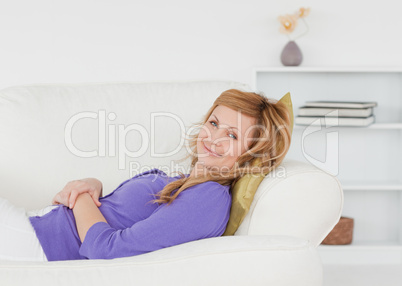 Pretty woman taking a rest and posing while lying on a sofa