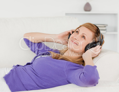 Beautiful red-haired woman listening to music