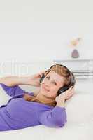 Smiling red-haired woman listening to music