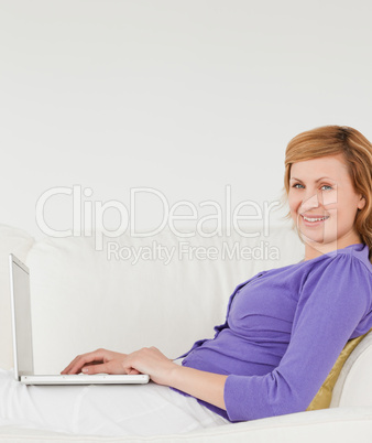Good looking red-haired woman using a laptop