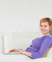 Good looking red-haired woman using a laptop