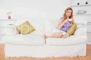 Beautiful red-haired woman holding a cup of coffee