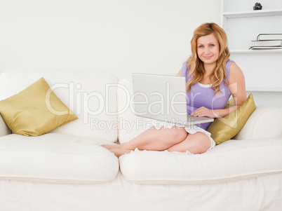 Attractive red-haired woman using laptop