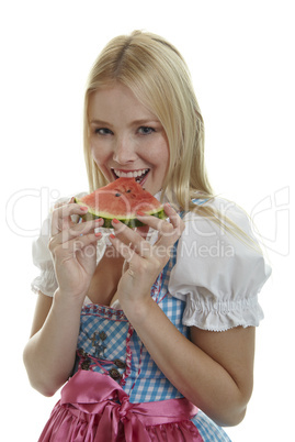 Frau im Dirndl isst Wassermelone