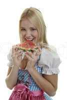 Frau im Dirndl isst Wassermelone