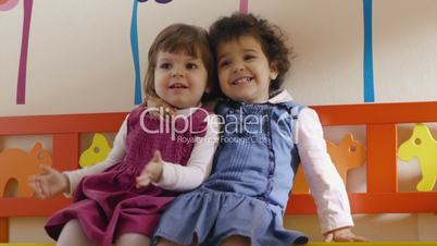 Baby girls playing and smiling in kindergarten