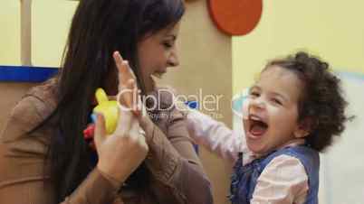 Pre-school: teacher and baby girl playing