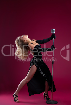 Young beauty Singer With Microphone on red